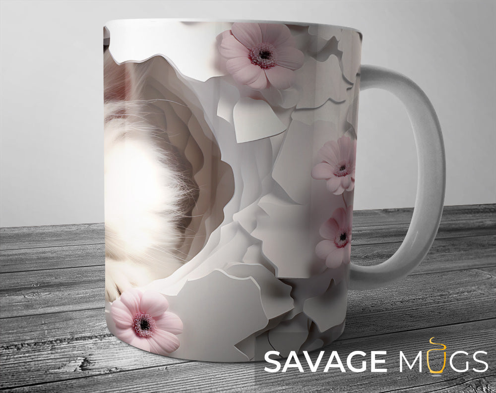 White ceramic mug with 3D illusion kitten design surrounded by soft pink flowers