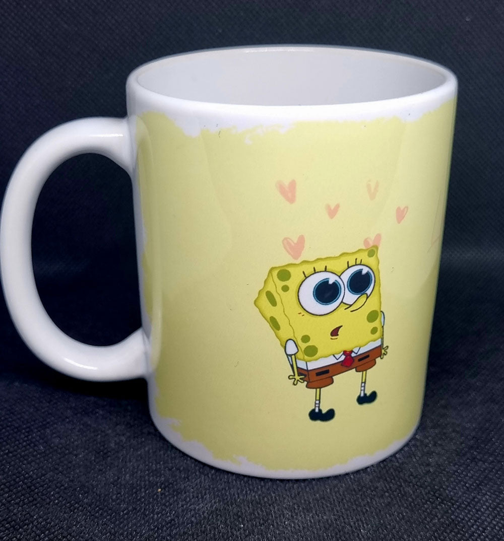 White ceramic mug featuring cute sea sponge cartoon inspired design with hearts