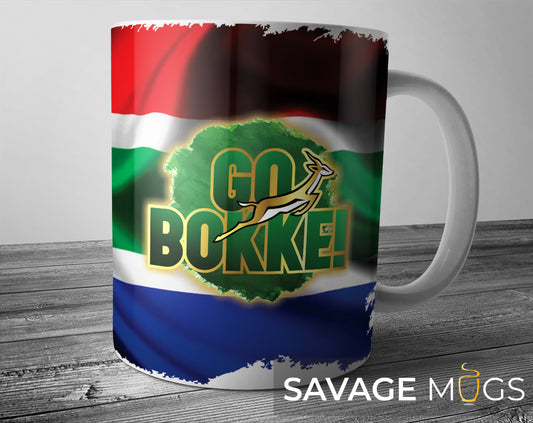 White ceramic mug with Go Bokke rugby design and South African flag background