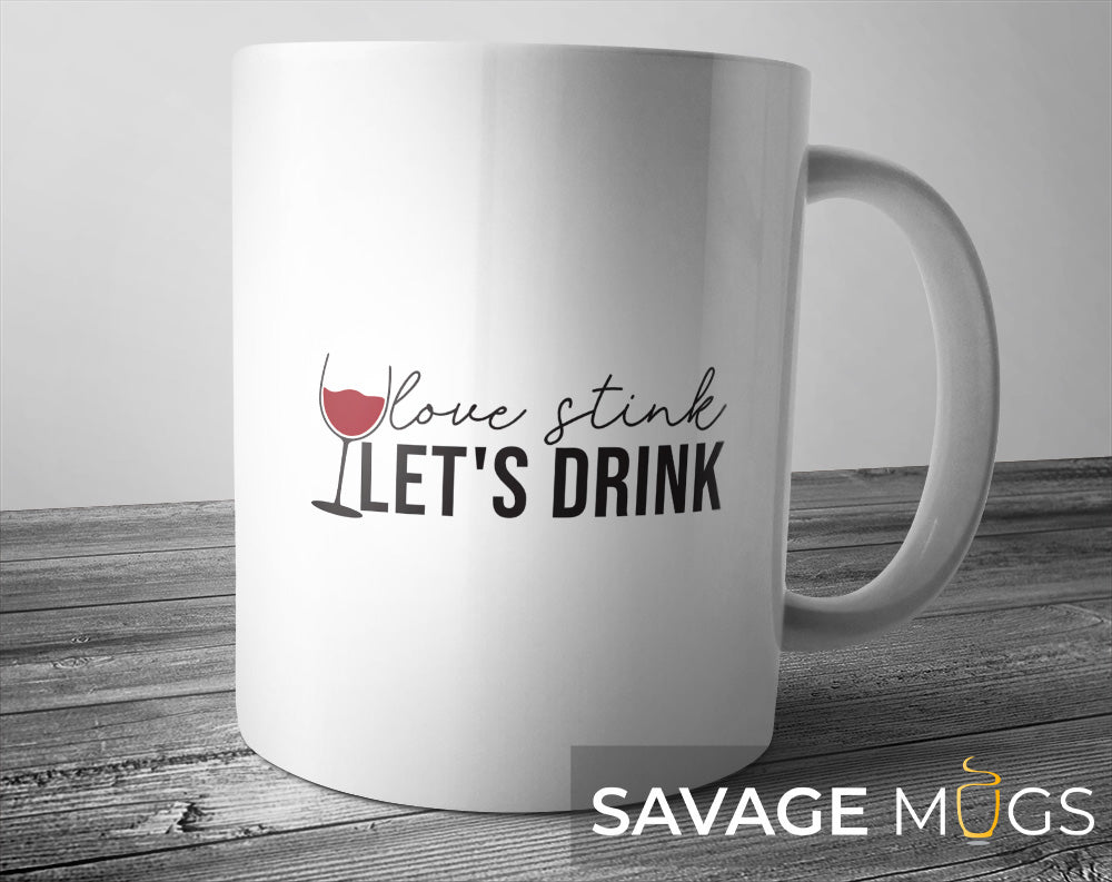 White ceramic mug with Love Stinks Let’s Drink text and wine glass design