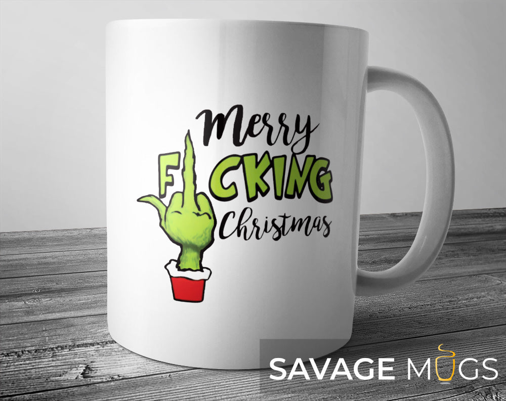 White ceramic mug with funny Merry F*cking Christmas design and green Grinch hand gesture