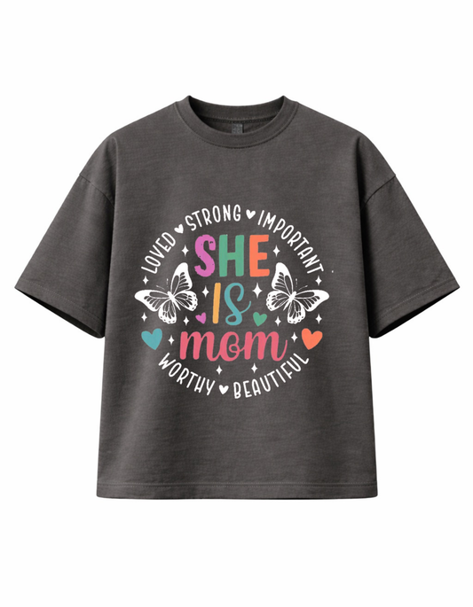 Dark grey 300 GSM boxy fit cotton T-shirt with “She Is Mom” affirmation design, butterflies and colourful text, ideal Mother’s Day gift