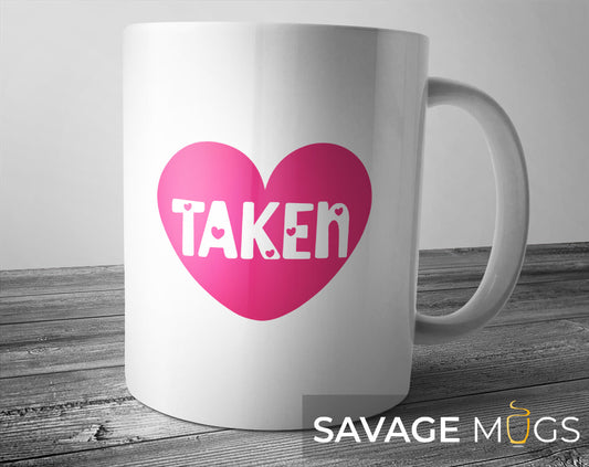 White ceramic mug with pink heart and Taken relationship design